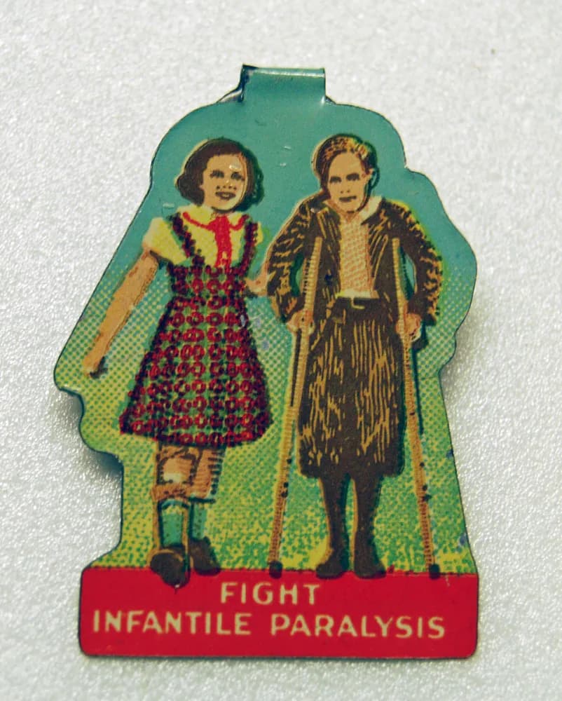 Metal button with an image a boy and girl; the boy has crutches. Text on the bottom of the button reads: "Fight Infantile Paralysis."